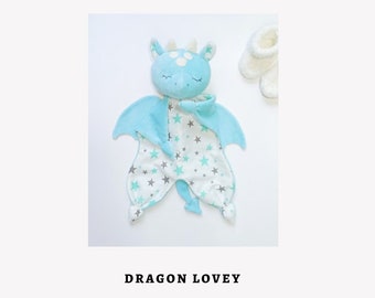 May include: A blue and white dragon lovey with a star pattern. The dragon has a light blue body with white stars and a white face with blue eyes. The lovey has a white background with blue stars.