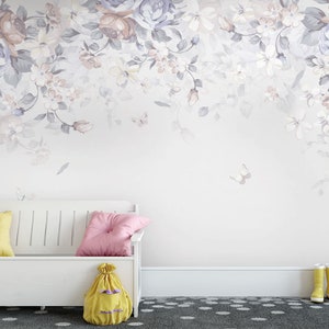 May include: A white bench with a yellow and pink cushion on it. The bench is in front of a wall with a floral wallpaper design. The wallpaper features a light purple and white floral pattern with butterflies.