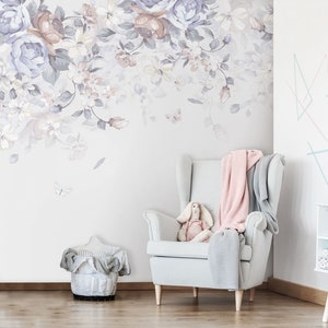 May include: A white armchair with a pink and grey throw blanket, a stuffed bunny rabbit, and a floral wallpaper with butterflies.