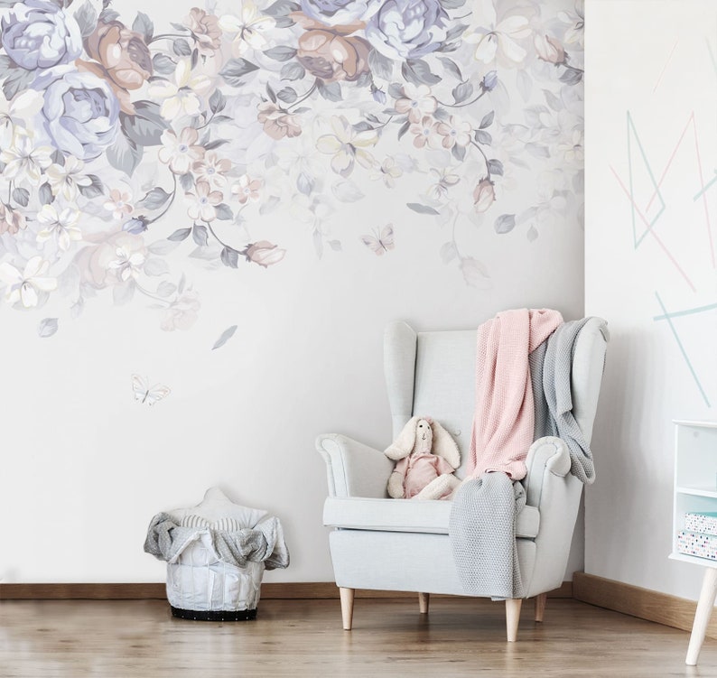 May include: A white armchair with a pink and grey throw blanket, a stuffed bunny rabbit, and a floral wallpaper with butterflies.