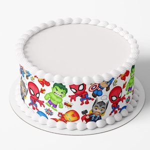 May include: A round white cake with a white frosting border. The cake's side is decorated with a colourful pattern of cartoon superheroes, including Spider-Man, Hulk, and Captain America. The cake sits on a white plate.