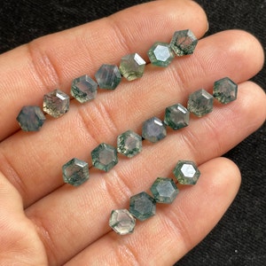Puede incluir: Una colección de 12 cuentas de piedra preciosa de ágata verde musgo, cada una cortada en forma hexagonal. Las cuentas son facetadas y tienen un aspecto natural y terroso.