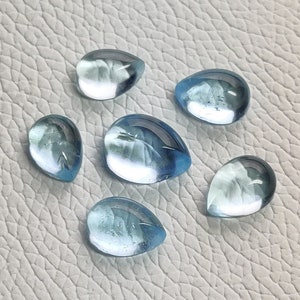 May include: Six teardrop-shaped, light blue gemstones with a translucent finish.