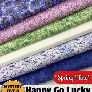 May include: A stack of patterned fabric rolls in various colors. The fabrics feature floral and abstract designs in shades of blue, purple, green, and white. The text "Spring Fling" is visible on a red banner. The text "Happy Go Lucky Mini-Mystery #5" is also visible.