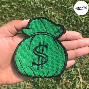 May include: Green money bag patch with a black dollar sign embroidered on it.