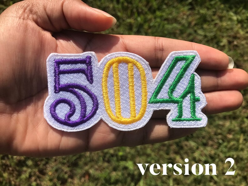 May include: Purple, yellow, and green embroidered patch with the numbers 504. The patch is on a white background.