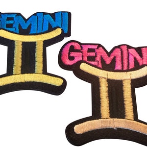 May include: Two embroidered iron-on patches featuring the Gemini zodiac sign with the word "Gemini" in blue and pink lettering.