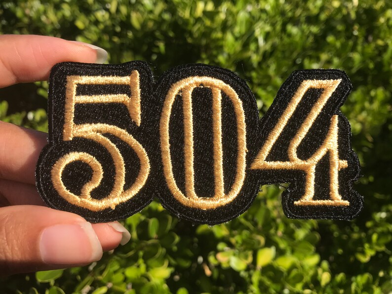 May include: A black fabric patch with the numbers 504 embroidered in gold thread.