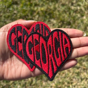 May include: Two red heart-shaped patches with black embroidered lettering that reads "GEORGIA".