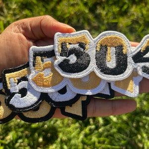 May include: A set of five embroidered iron-on patches featuring the numbers 504 in a dripping gold and black design. The patches are layered on top of each other, with the largest patch on the bottom and the smallest patch on top.