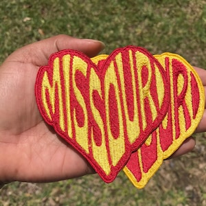 May include: Two heart-shaped embroidered patches with the word "MISSOURI" in yellow and red lettering.