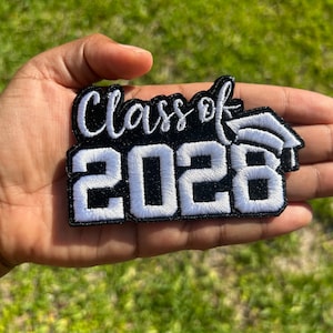 May include: Black and white embroidered patch with the text "Class of 2028" and a graduation cap.