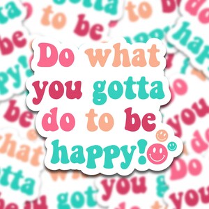 May include: A colorful sticker with the text "Do what you gotta do to be happy!" in a retro font. The sticker has a white background with pink, red, orange, turquoise, and teal text. There are two smiley faces on the sticker.