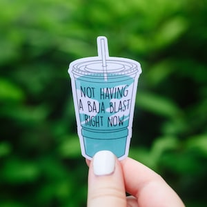 May include: A sticker of a blue and white cup with a straw and the text "Not having a Baja Blast right now".
