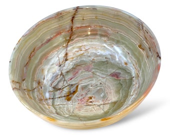 May include: A large, round bowl made of green, white, and brown onyx. The bowl has a swirling pattern and is perfect for serving snacks or decorative purposes.