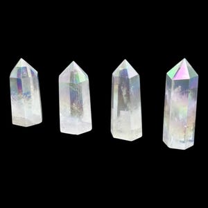 May include: Four iridescent clear quartz crystal points, each with a unique rainbow sheen. The points are arranged in a row on a black background.