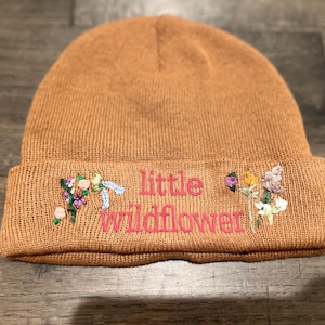 Bruine beanie met 'Little Wildflower' geschreven en met de hand geborduurde wilde bloemen