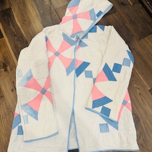 Women’s vintage quilt jacket with windmill pattern, blue trim, open front and hood. Handsewn with all pieces original vintage quilt