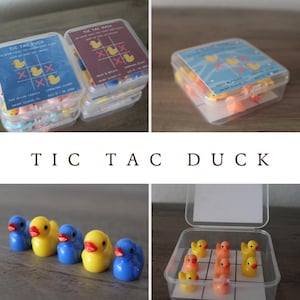 May include: A clear plastic container filled with yellow rubber ducks. The container has a tic-tac-toe board printed on the bottom. The game is called "Tic Tac Duck".