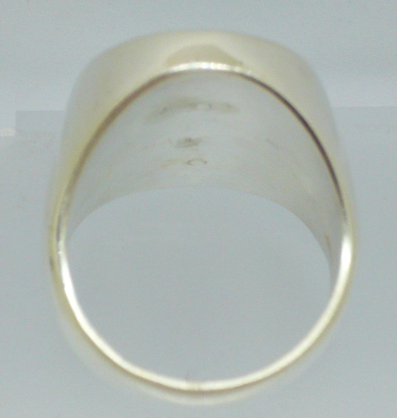 May include: The inside of a silver ring with a smooth, polished finish.