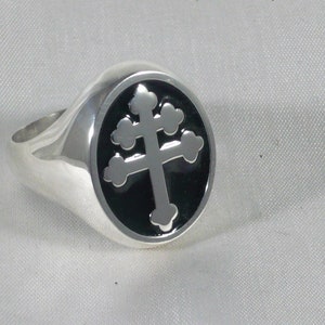 Op de afbeelding: Een zilveren ring met een ovale top van zwart emaille met een zilveren Maltese kruisontwerp.