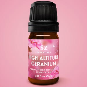 May include: A small brown glass bottle with a black cap, labeled "HIGH ALTITUDE GERANIUM" with pink floral accents. The label reads "PREMIUM ESSENTIAL OIL - HIMALAYAN" and contains 0.17 fl. oz. (5 ml).