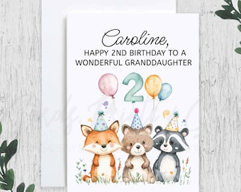 May include: A birthday card with a watercolor illustration of a fox, raccoon, and bear wearing party hats. The card says "Caroline, Happy 2nd Birthday to a Wonderful Granddaughter" and has a large number "2" with balloons.