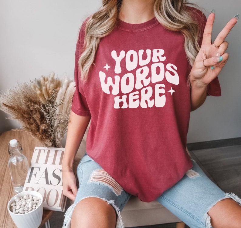 May include: A maroon t-shirt with the text "YOUR WORDS HERE" in a retro, white font.