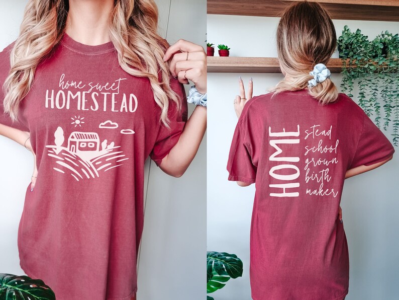 May include: A maroon t-shirt with the text "home sweet homestead" on the front and "home stead school grown birth maker" on the back.