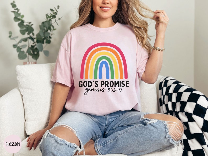K&ouml;nnte beinhalten: Ein pinkfarbenes T-Shirt mit einem Regenbogen-Motiv und dem Text "GOD'S PROMISE genesis 9:13-17".