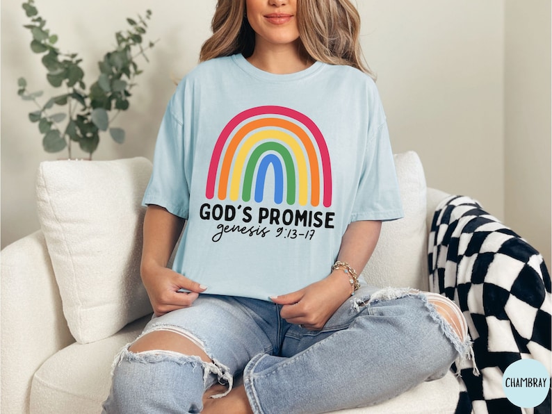 K&ouml;nnte beinhalten: Ein hellblaues T-Shirt mit einem Regenbogen-Motiv und dem Text "GOD'S PROMISE genesis 9:13-17".