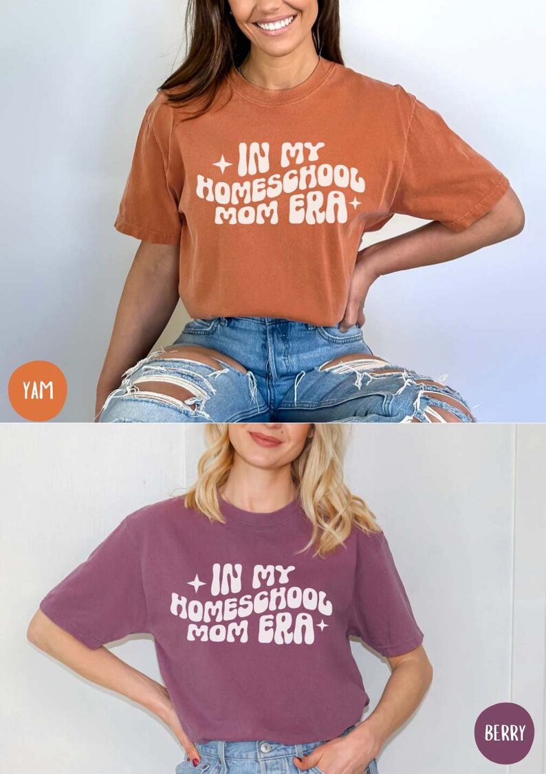 May include: Two t-shirts with the text "In My Homeschool Mom Era" in a retro font. The top shirt is rust orange and the bottom shirt is a deep purple.