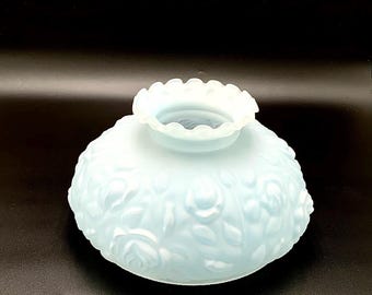 May include: A pale blue, translucent glass lamp shade featuring a raised, embossed floral pattern of roses and leaves across its rounded surface. The top opening is finished with a delicate, scalloped, and ruffled edge design.