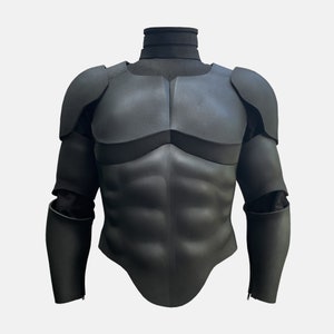 May include: Black foam armor for cosplay or costume. The armor features a chest plate with sculpted muscle definition and matching arm pieces.