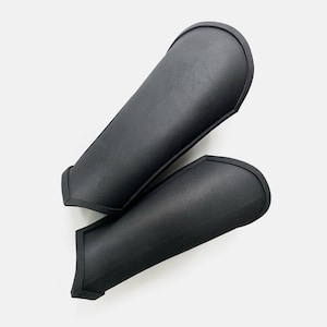 May include: A pair of black foam arm guards. The guards are designed to protect the arms from impact.
