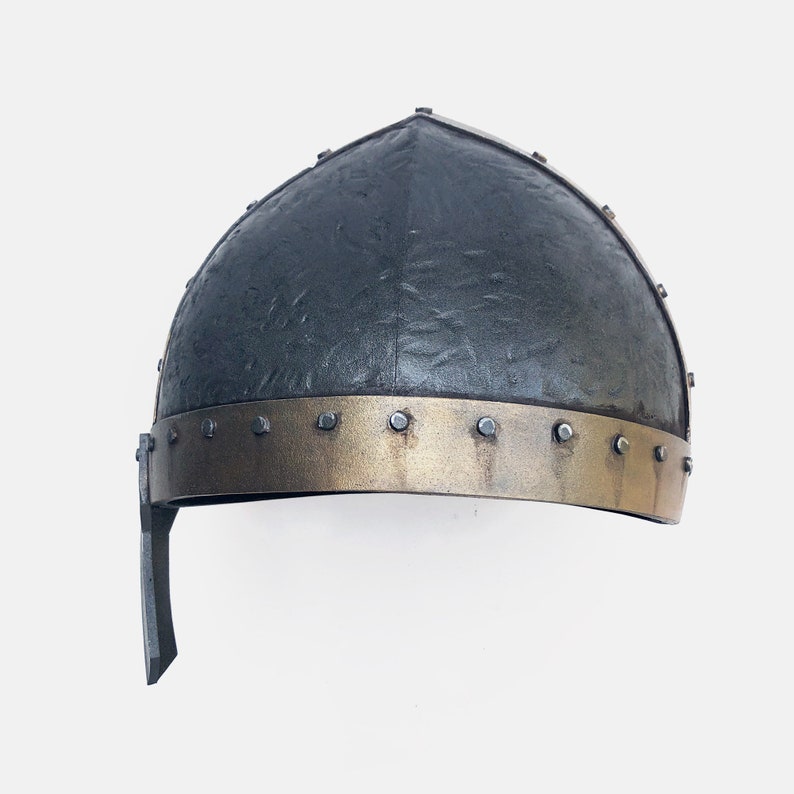 May include: A black helmet with a gold band and metal rivets. The helmet has a textured surface and a pointed top.
