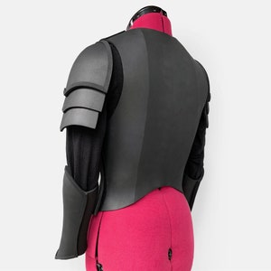 May include: Black padded armor with a layered design on the shoulders and arms. The armor is made of foam and is designed to be lightweight and comfortable.