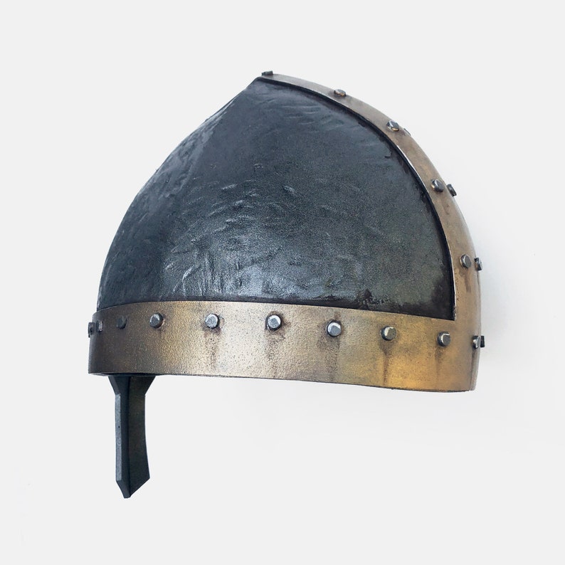 May include: A black and gold helmet with a textured surface and a band of metal rivets around the bottom edge.