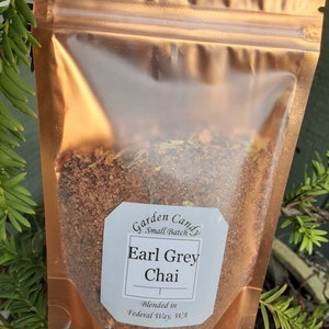May include: A gold foil pouch with a white label that reads "Garden Candy Small Batch Earl Grey Chai Blended in Federal Way, WA". The pouch contains loose leaf tea.