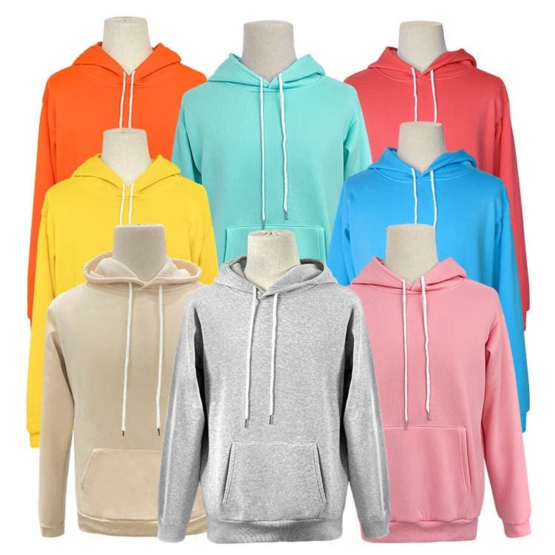 May include: Ten hooded sweatshirts in various colors, including orange, yellow, turquoise, blue, pink, and gray. The sweatshirts have a drawstring hood and a kangaroo pocket.