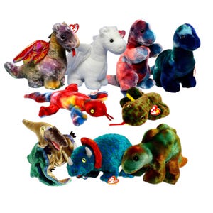 May include: A collection of colorful plush dinosaur toys, including dragons, a triceratops, and a snake. The toys feature various colors and patterns, with tags attached.