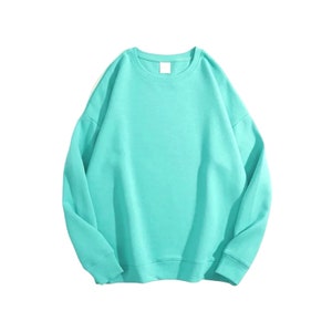 Peut inclure: Un sweat &agrave; manches longues turquoise avec un col rond.