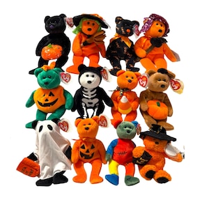 May include: A collection of 12 Halloween-themed beanie babies. The beanie babies are all different colours and have different designs, including a pumpkin, a ghost, a skeleton, and a witch.