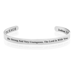 Può includere: Un bracciale a polsino color argento con testo inciso. Il bracciale presenta le parole "COURAGE" e "Joshua 1:9". Il testo principale recita: "Be Strong And Very Courageous, The Lord Is With You".