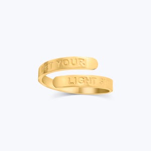 May include: Gold-toned ring with the words "Let Your Light Shine" engraved on it.