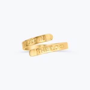 Puede incluir: Anillo dorado con las palabras "Trust in the Lord" grabadas.