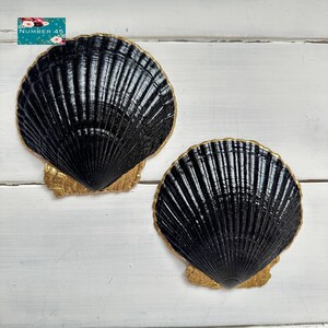 May include: Two black scallop shell-shaped decorative pieces with gold-colored edges and bases. The shells have a textured, ridged surface. The text "NUMBER 45" is in the upper left corner.