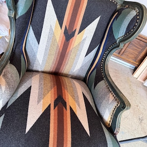 May include: A wingback chair with a black, green, and brown patterned upholstery. The chair has a high back and a curved, ornate frame.