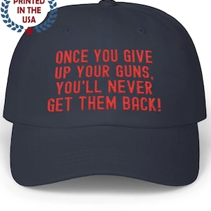 Könnte beinhalten: Marineblaue Baseballkappe mit rotem Text: "ONCE YOU GIVE UP YOUR GUNS, YOU'LL NEVER GET THEM BACK!". Die Kappe hat auch ein "PRINTED IN THE USA"-Logo. Die Mütze ist ein klassisches Sechs-Panel-Design mit gebogenem Schirm.