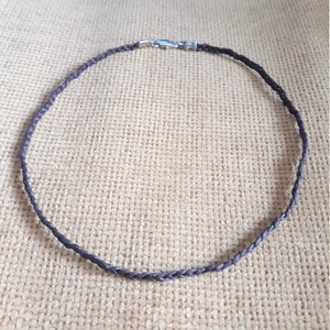 May include: A brown leather cord necklace with a silver clasp.